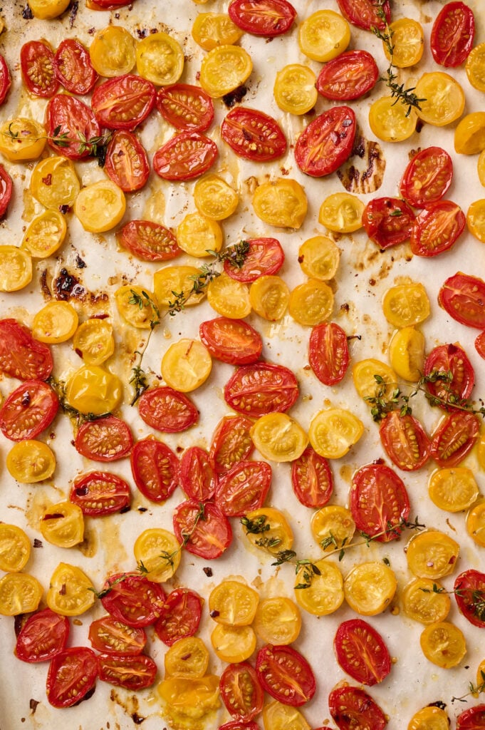 Close-up of roasted cherry tomatoes on a baking sheet with caramelized edges
