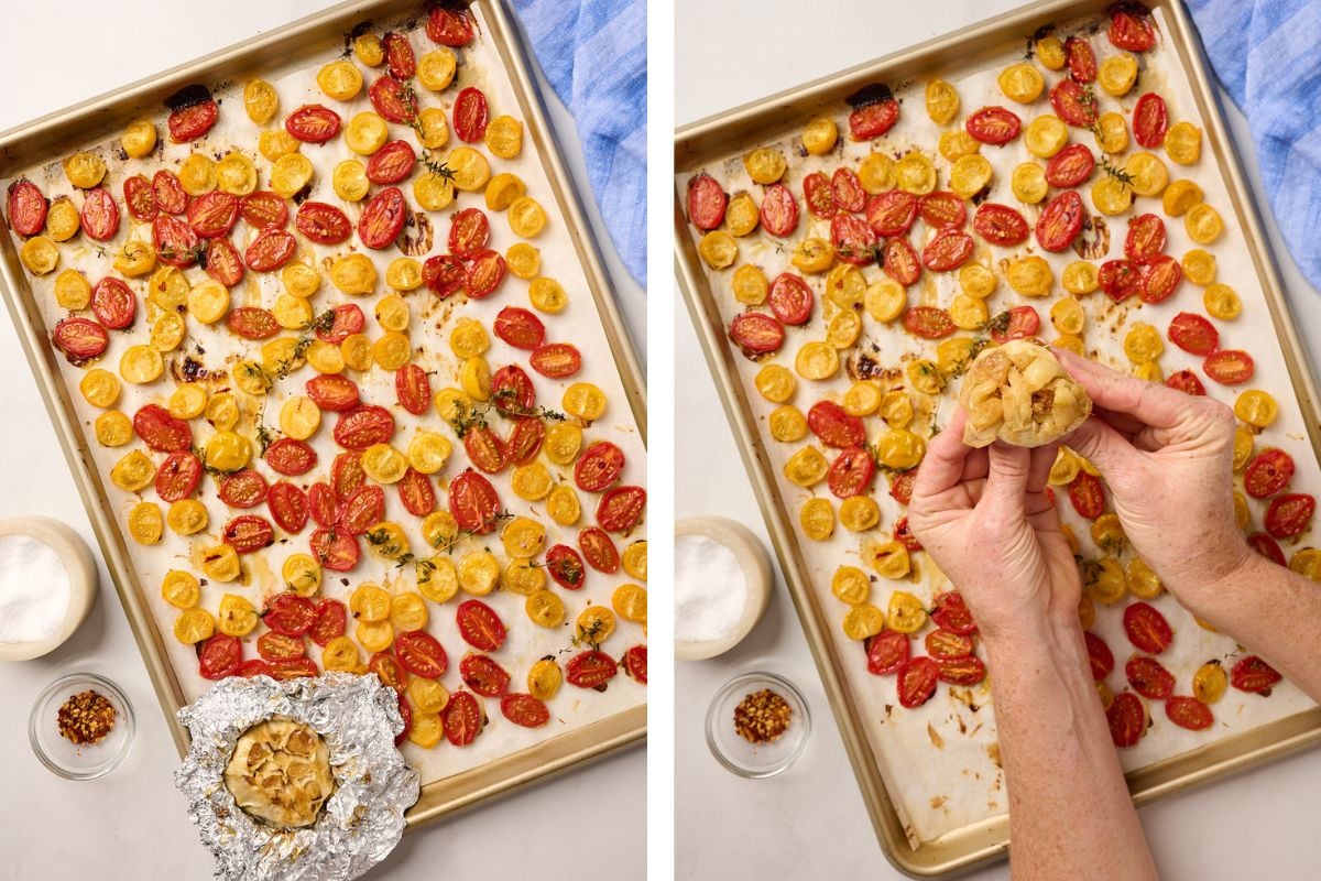 Roasted tomatoes on a tray with a hand pressing a head of roasted garlic