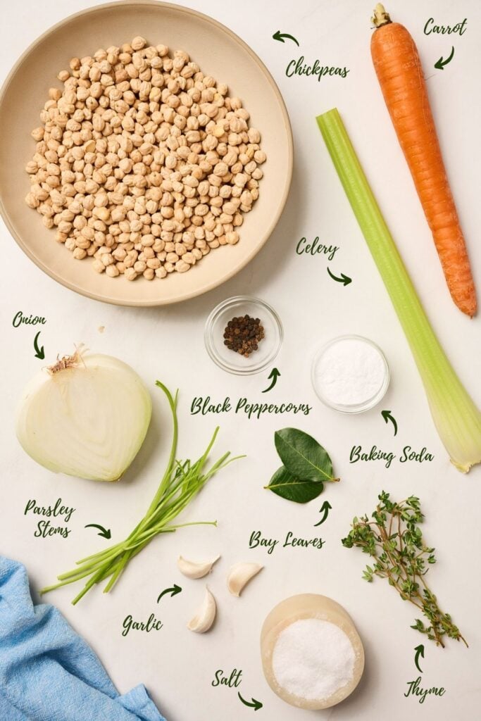 Dried chickpeas, salt, baking soda, aromatics, and lemon arranged for cooking preparation