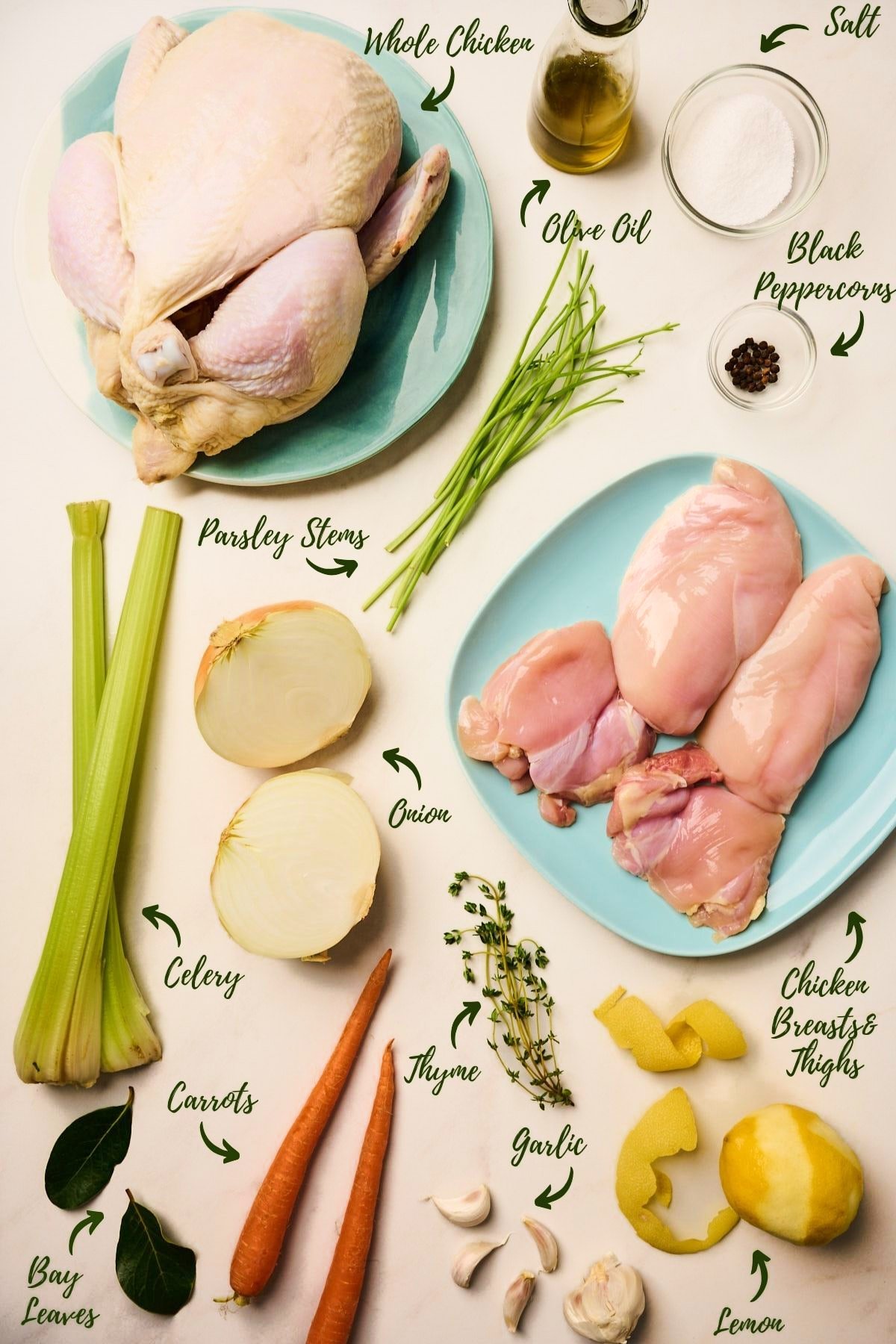 Overhead view of prepped ingredients for shredded chicken including vegetables, herbs, and a whole raw chicken