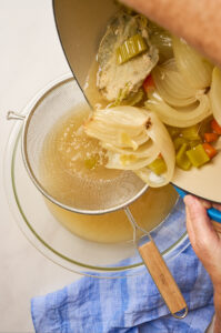 Straining broth from the poaching process