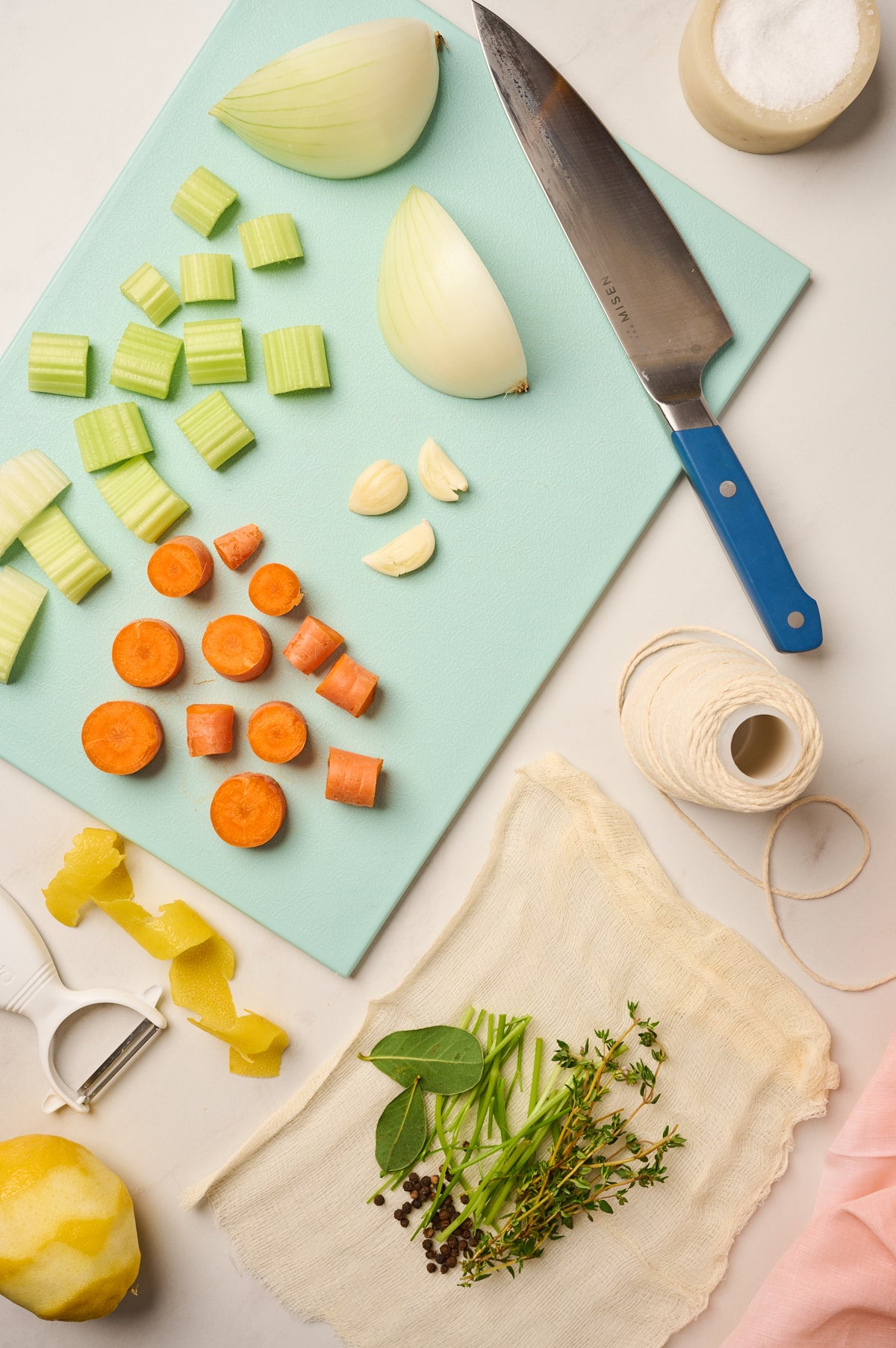 Fresh herbs wrapped in cheesecloth with chopped vegetables for making herb sachet for broth