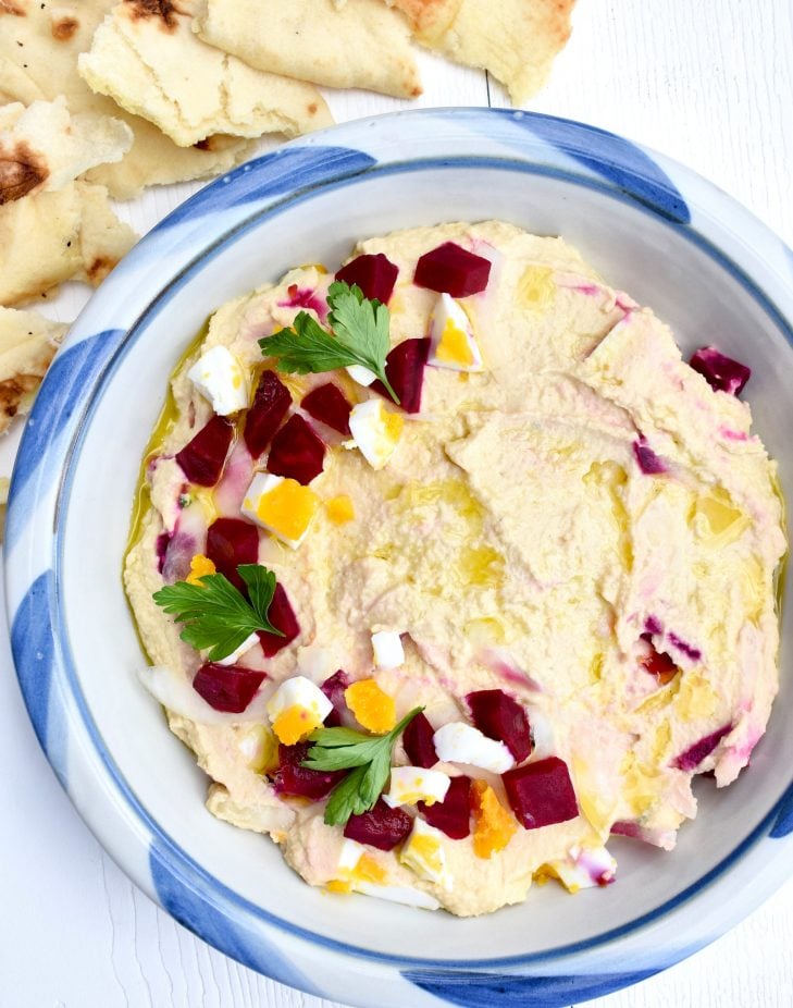 Warm Hummus with Roasted Pickled Beets, Onions, and Egg in a bowl 